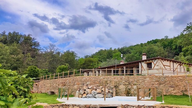 A stone-walled building with a wooden deck and a stone staircase leading to a door. - Hotel Rural San Giles (Aldeanueva de la Vera)