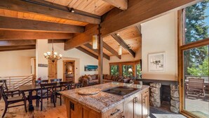 Una cocina amplia con vigas de madera, encimeras de granito y chimenea de piedra.
