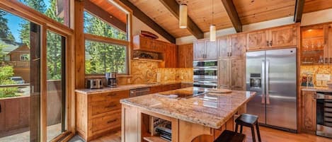Enjoy cooking in this spacious kitchen with a large island and cabinetry, offering views of the surrounding landscape.