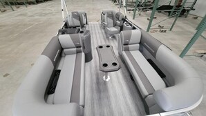 L'intérieur d'un bateau, avec des sièges, une console centrale et un plancher en bois.