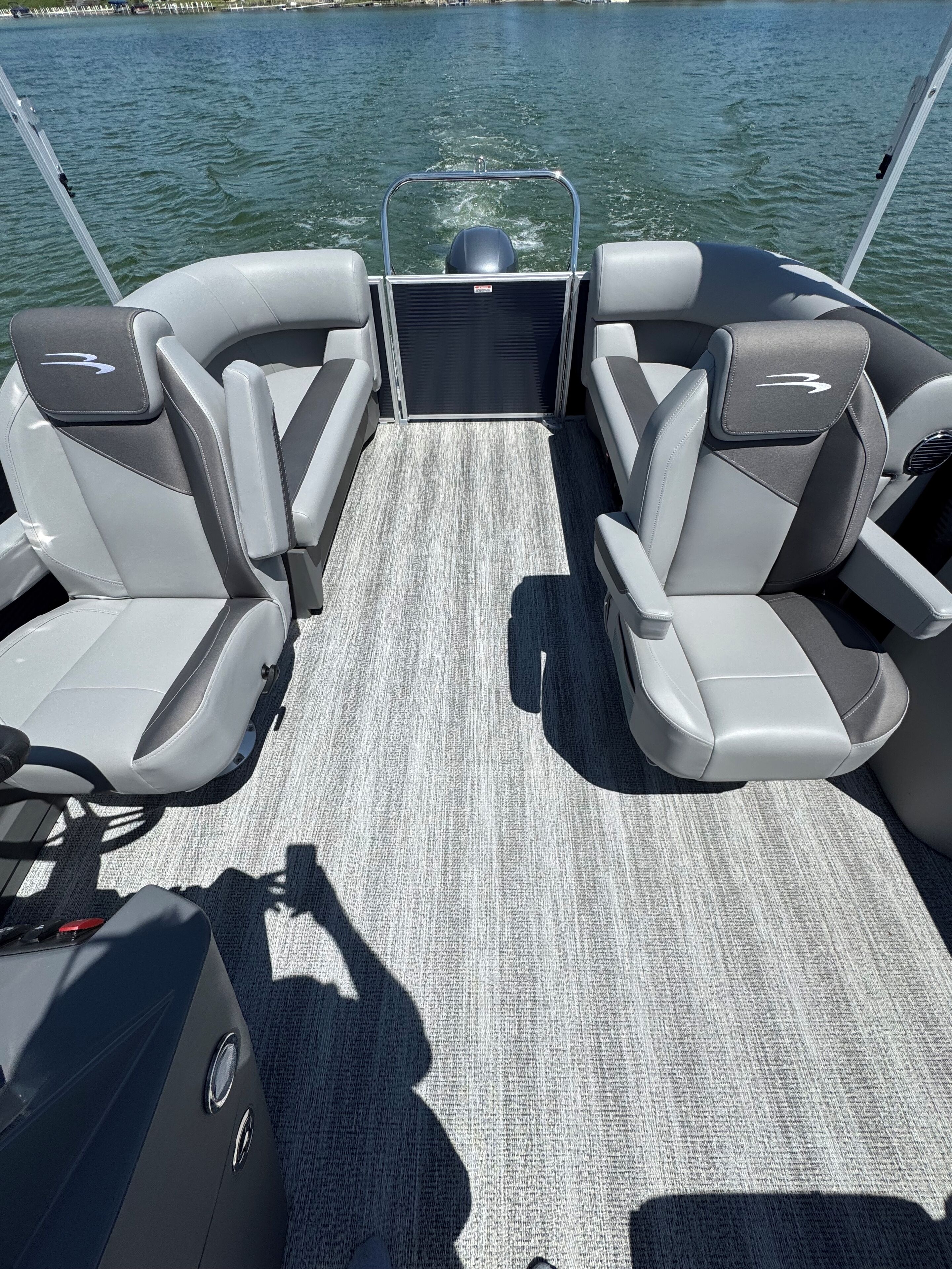 Bootinterieur met twee zithoeken, een centraal bedieningspaneel en uitzicht op het water.