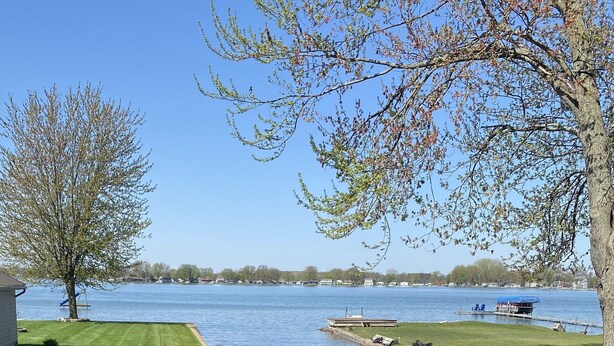 Une pelouse bien entretenue, verdoyante, offrant une vue dégagée sur un lac et un quai.