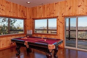 Enjoy a game of pool with a view of the surrounding landscape from this room's large windows.