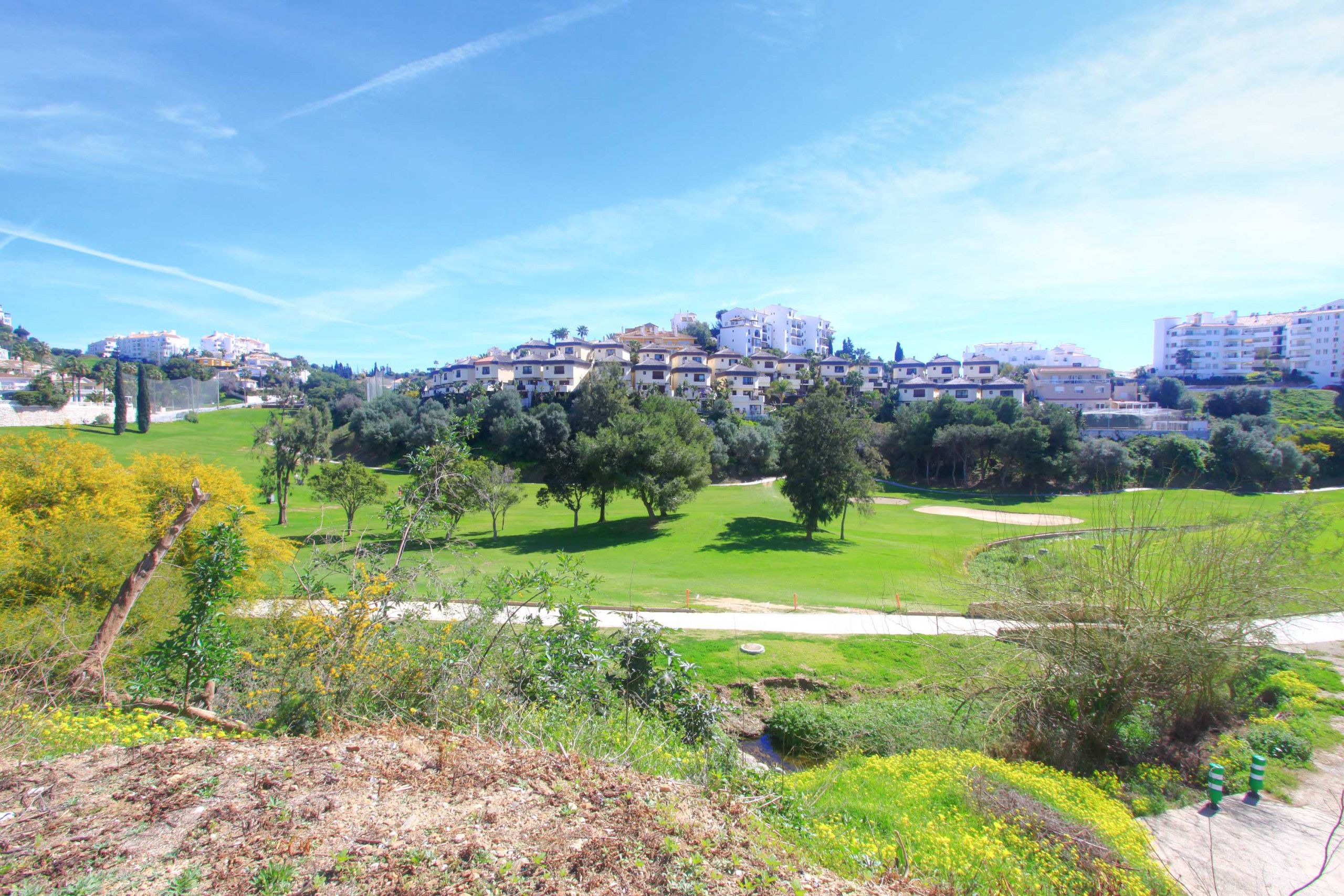 Ein Wohngebiet mit Golfplatz, Gebäuden und viel Grün.