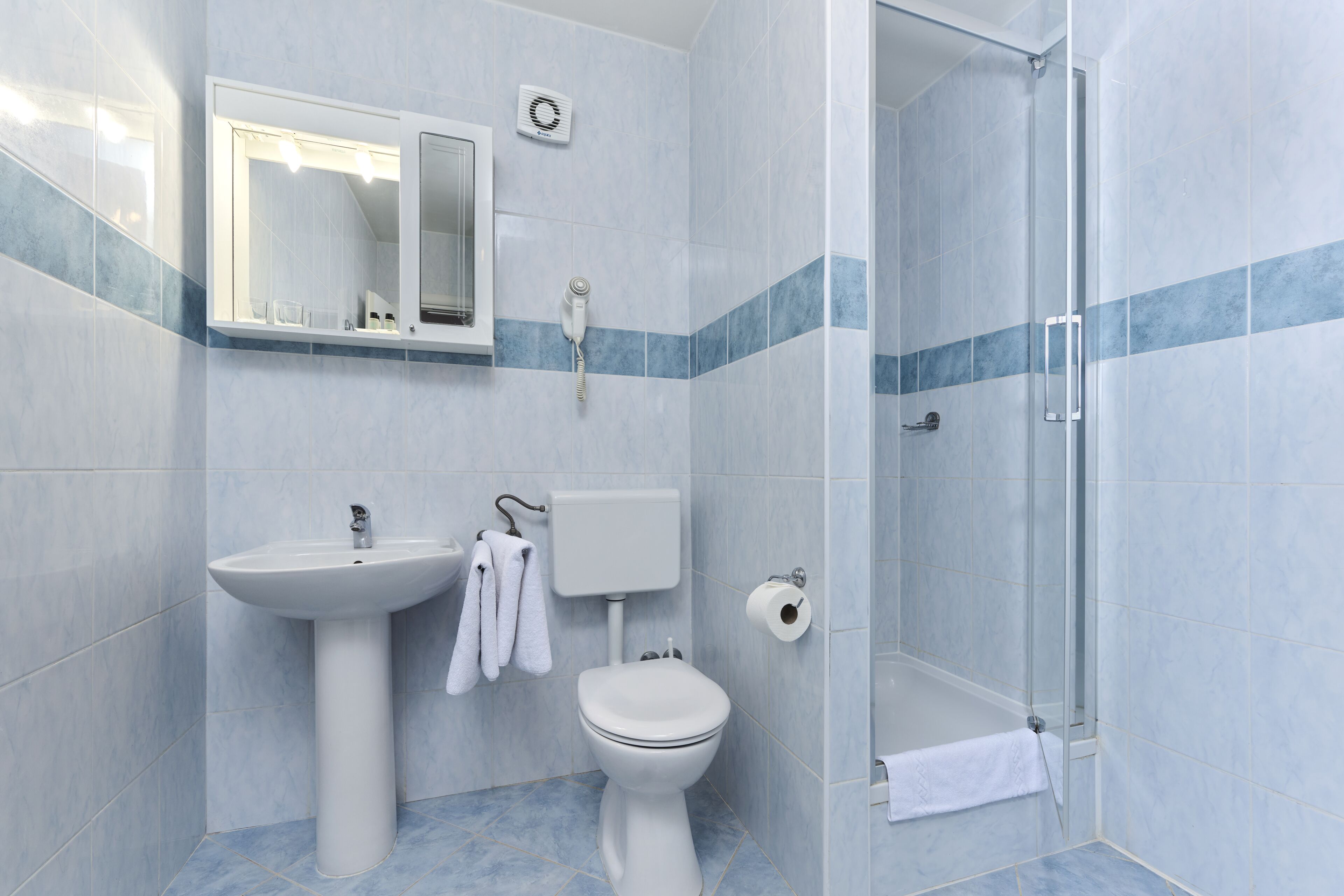 A bathroom with a sink, toilet, and shower.