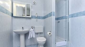 Une salle de bain avec un lavabo, des toilettes et une douche.