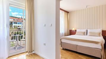 Habitación de hotel con cama, mesita de noche, una mesa con sillas y vistas al exterior.