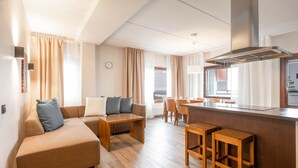 A modern hotel room with a living area, a dining area, and a kitchenette. - Ski-Inn RukaVillage (Kuusamo)