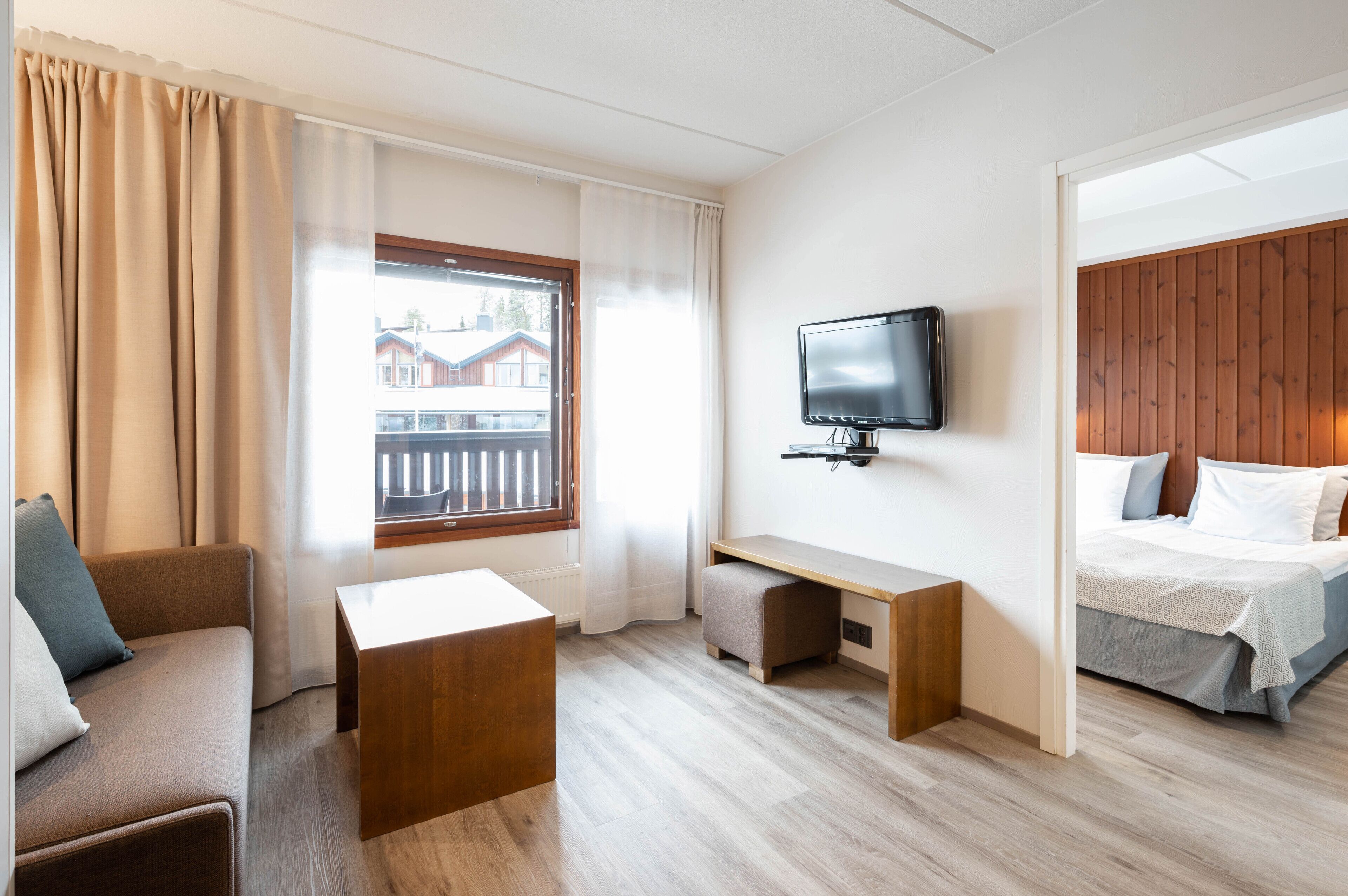 Una habitación de hotel con sofá, escritorio, cama y televisión.