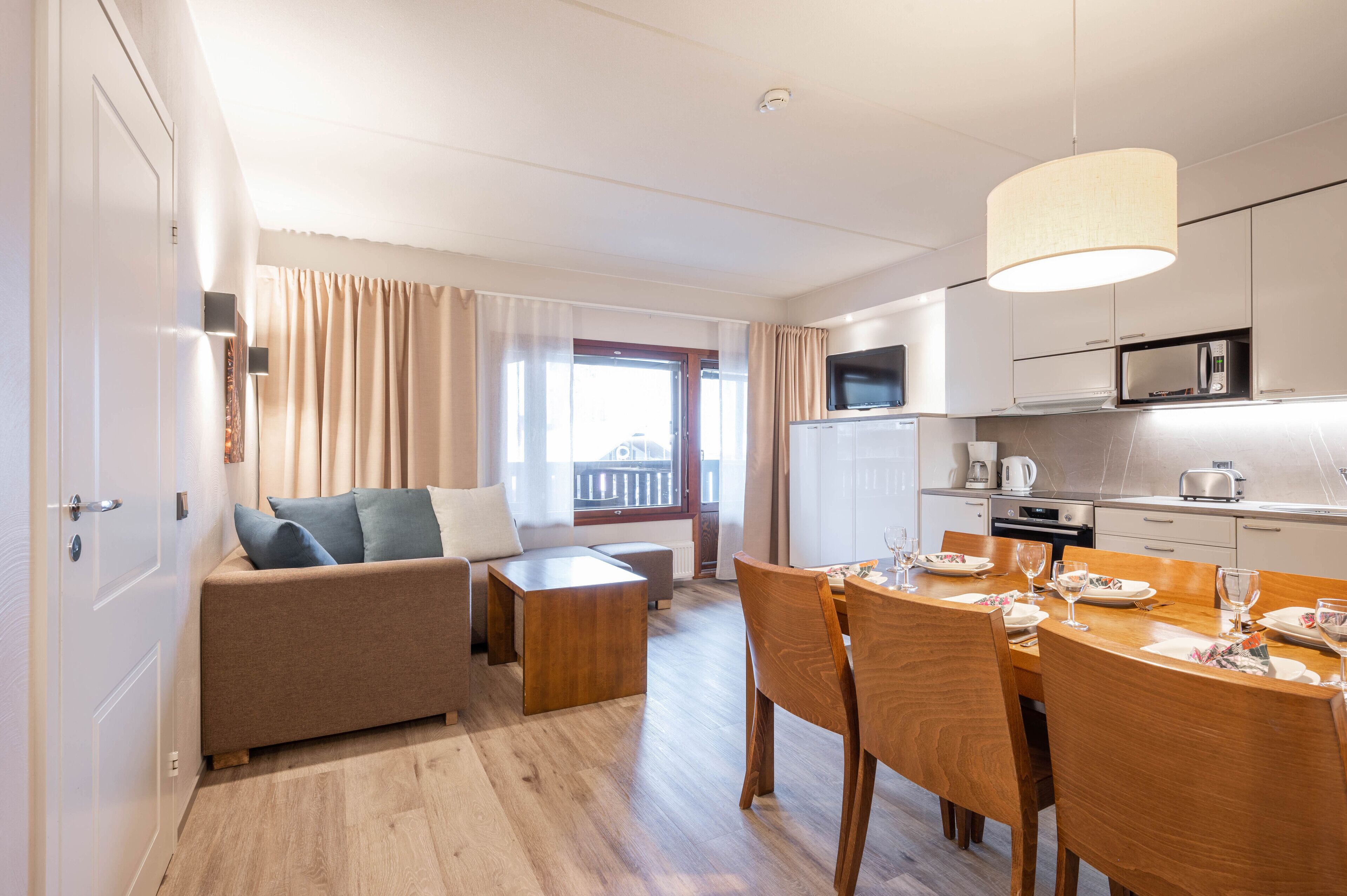 A modern apartment with a living area, dining space, and kitchenette.