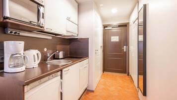 A compact kitchen with a Bosch coffee maker, a microwave, and a sink.