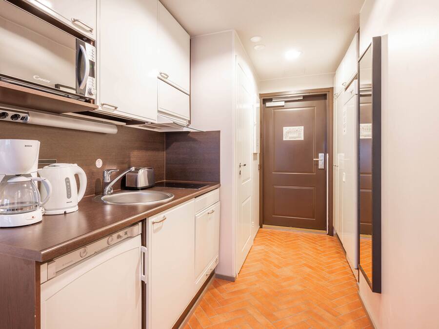 A compact kitchen with a Bosch coffee maker, a microwave, and a sink.