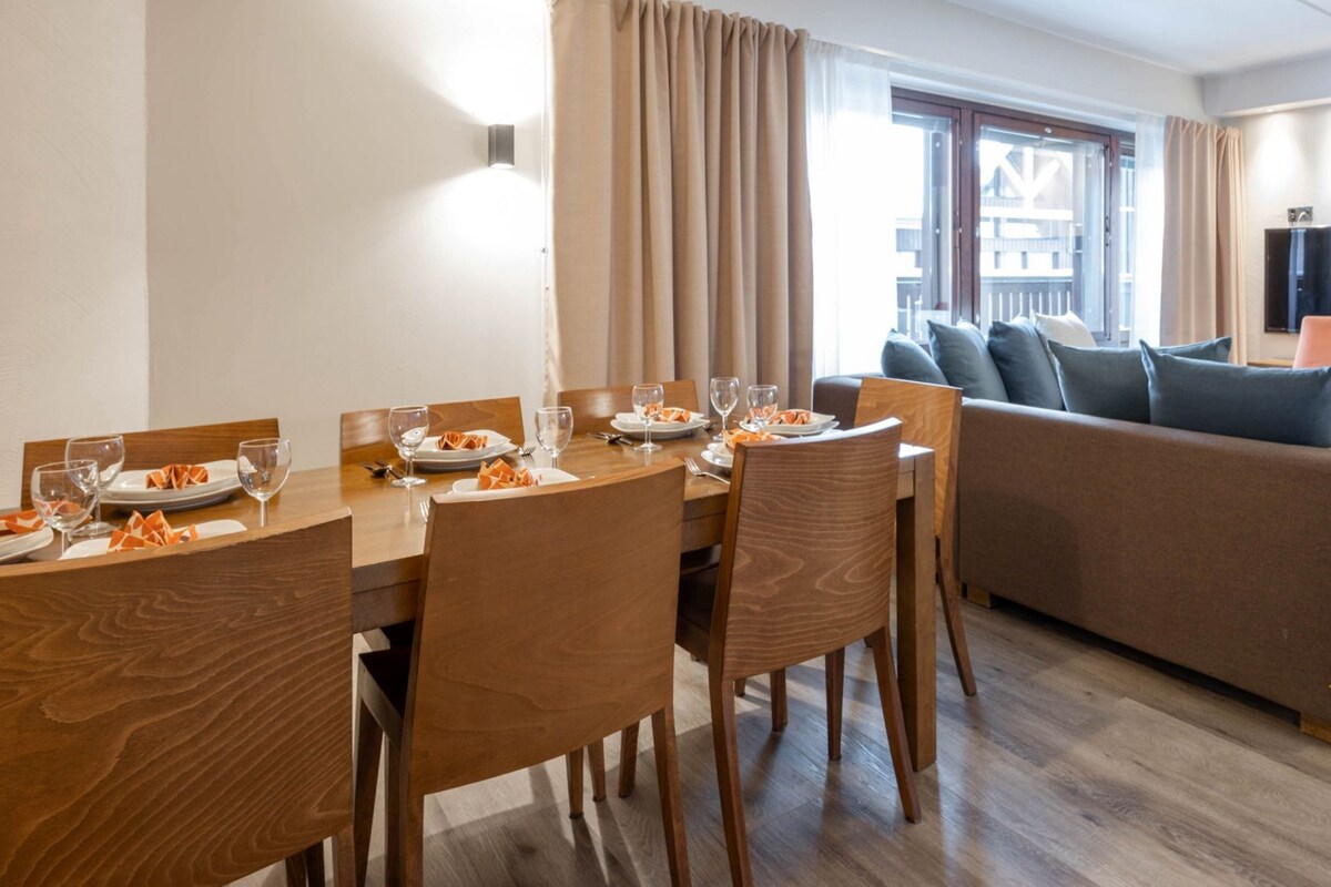 Une chambre d’hôtel moderne dotée d’un coin repas, d’un canapé et d’une télévision. Elle a été désignée comme lauréate des World Ski Awards 2023.