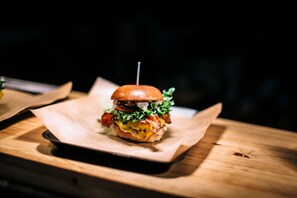 A burger on a wooden tray.