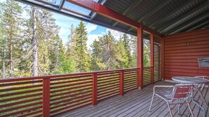 A wooden deck with red railings, a table, and chairs. - Ski-Inn MastonAitio (Kuusamo)