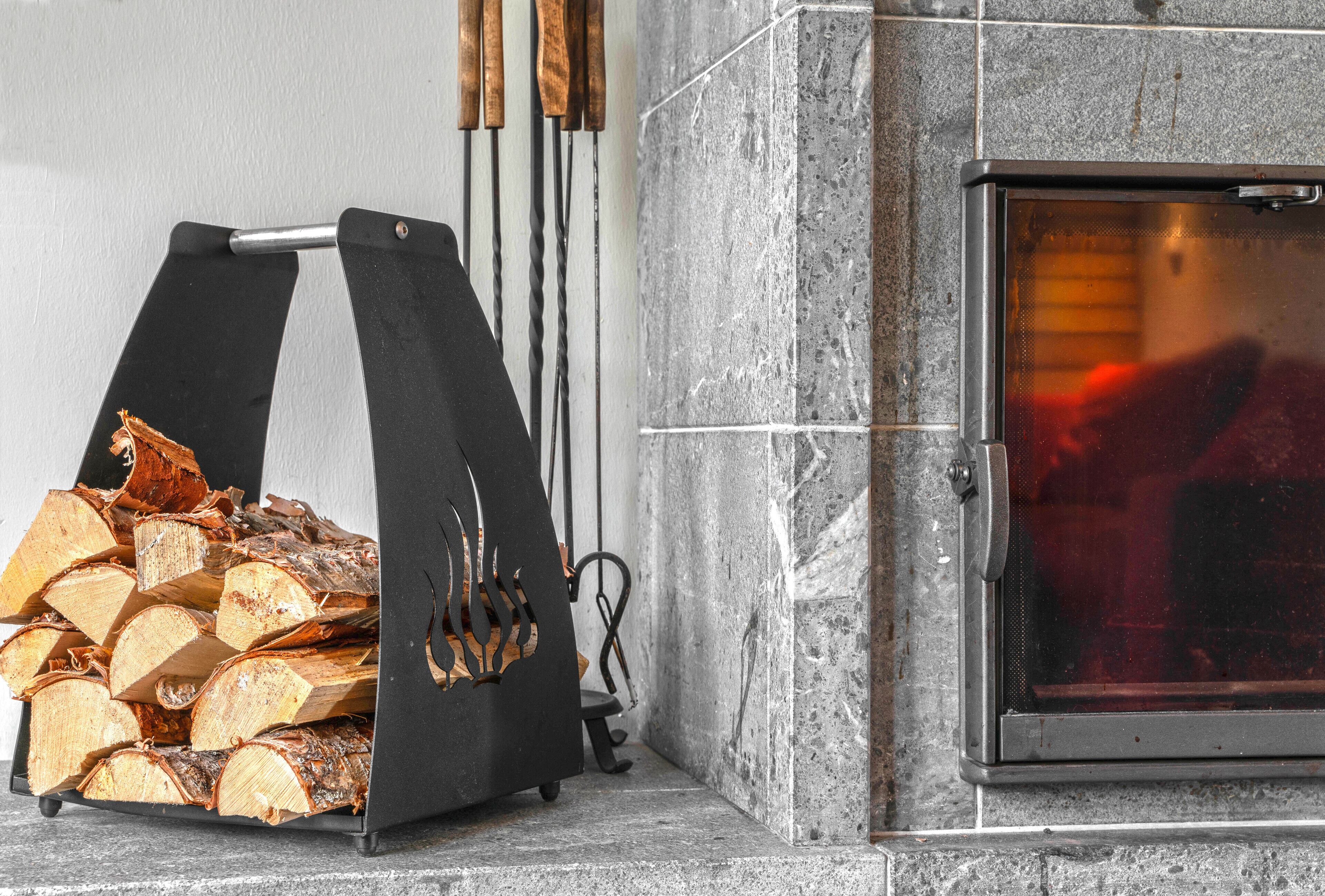 Una chimenea con un soporte de leña metálico y una salida de humos.