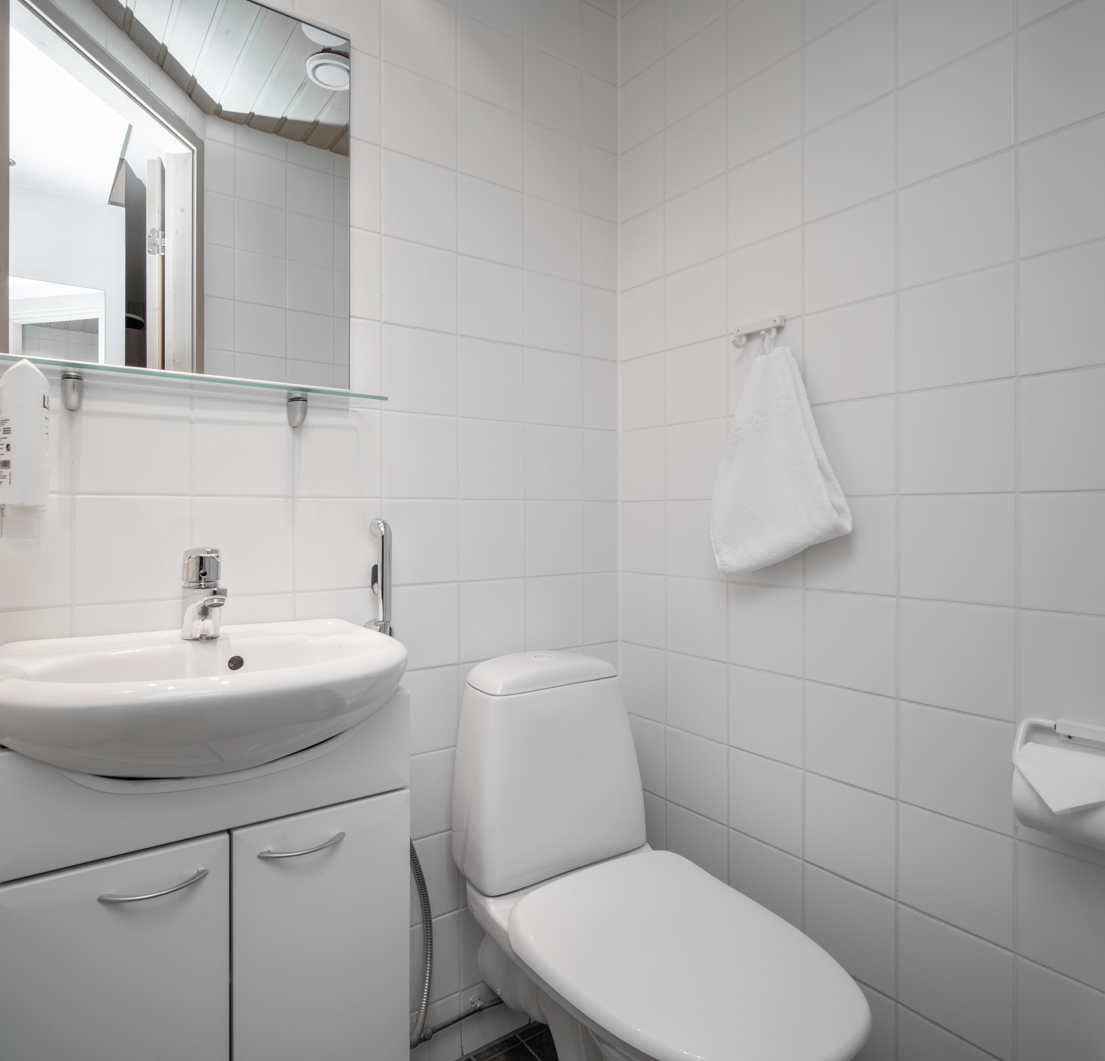 Une salle de bain moderne avec un lavabo, des toilettes et un bidet, le tout de couleur blanche.