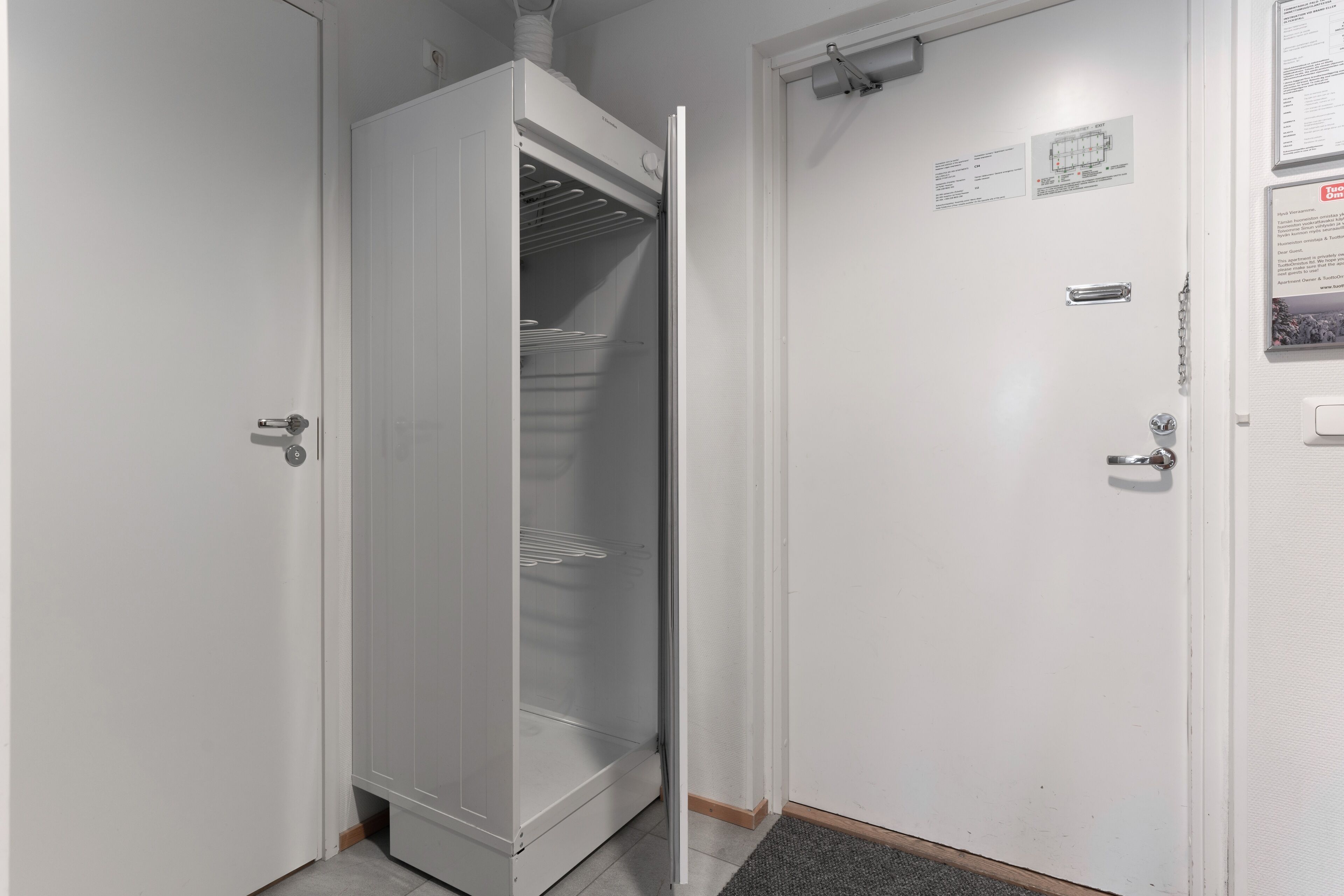 A white door with a metal handle and a small sign above it.