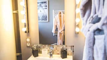 A bathroom with a sink, mirror, and lights.