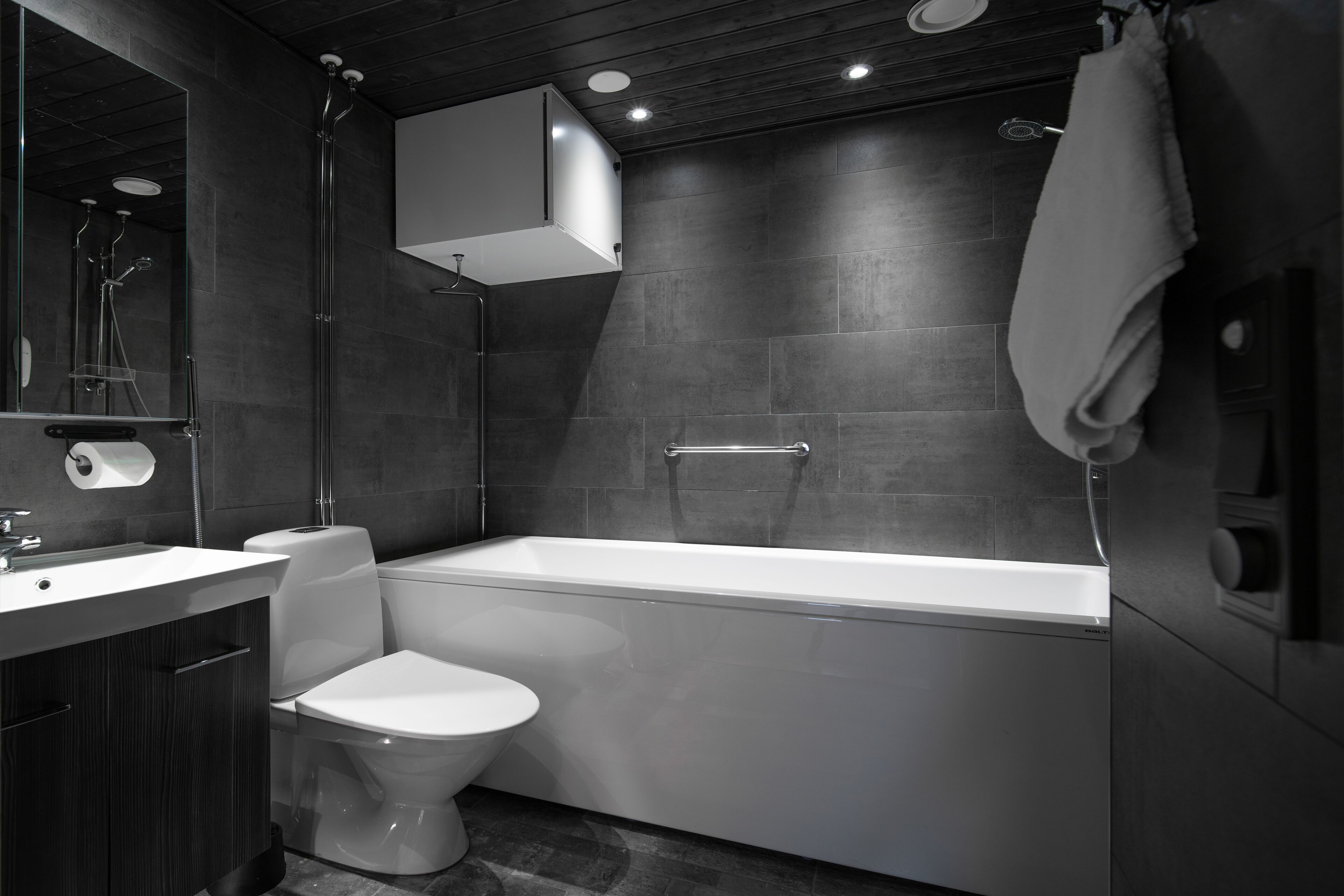 A modern bathroom with a bathtub, toilet, and sink.