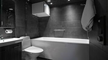 A modern bathroom with a bathtub, toilet, and sink.