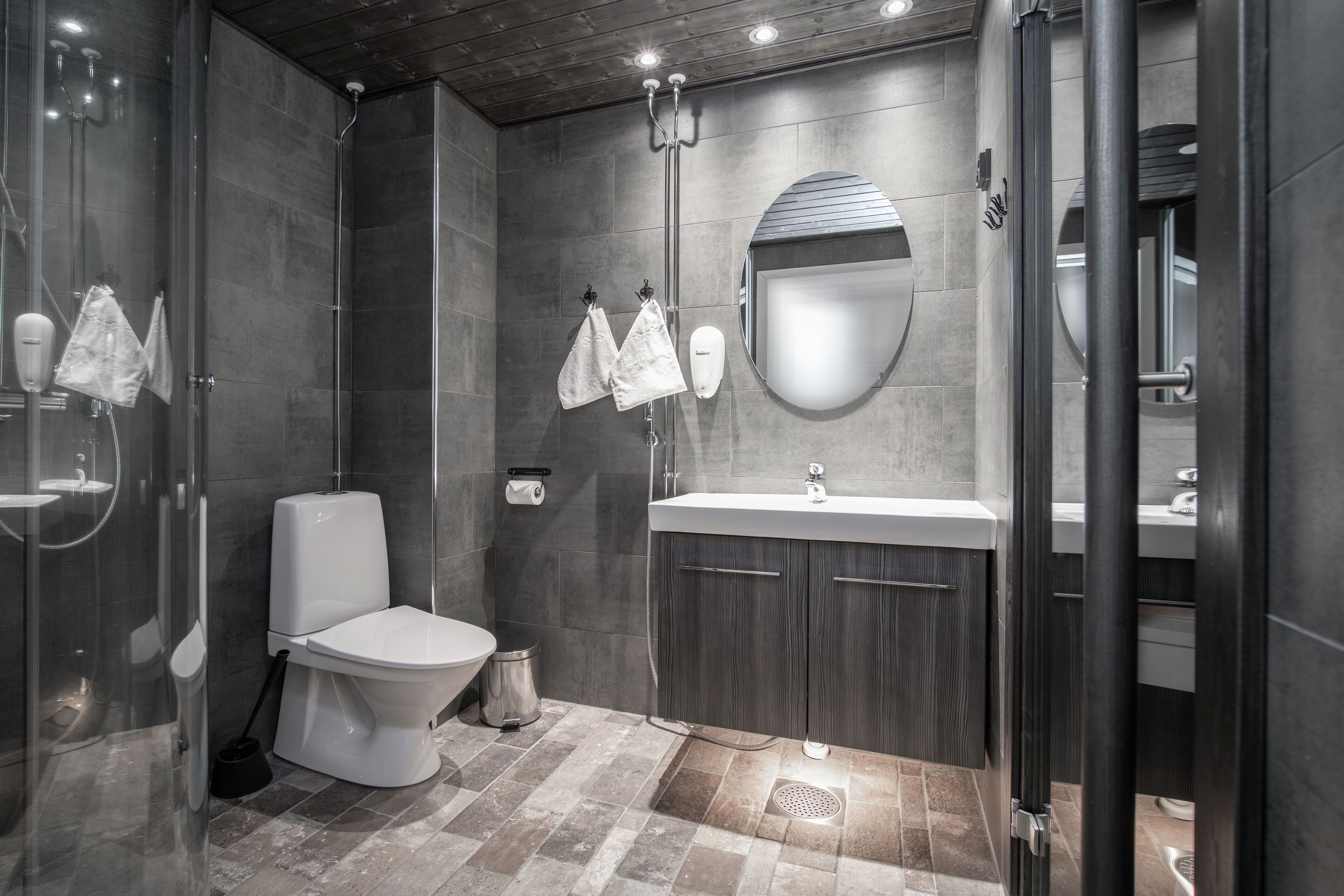 A modern bathroom with a shower, toilet, sink, and vanity.