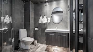 A modern bathroom with a shower, toilet, sink, and vanity.