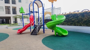 A playground with two slides, a climbing structure, and a yellow overhead shelter. - 2BR Apartment for 4 Pax at Ayodhya Residences (Tangerang)
