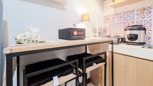 A kitchen with a travel bag, a water bottle, and a rice cooker on the counter.