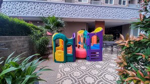 Un espace de jeux pour enfants avec des structures d’escalade colorées et un sol à motifs.