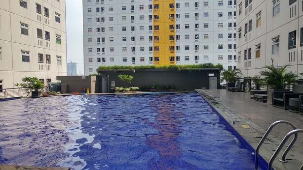 Una piscina con vistas a edificios altos en el fondo.