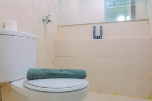 A bathroom with a toilet, a towel, and a shower. - Comfortable 2BR @ Green Palace Kalibata City Apartment (Jakarta)