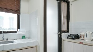 A kitchen with a sink, a dish rack, a kettle, and a coffee maker. - Comfortable and Homey Studio Apartment at Kebagusan City (Jakarta)