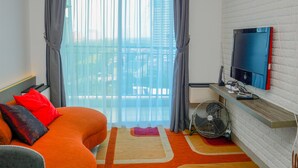 Ein modernes Hotelzimmer mit einem großen Bett, einem an der Wand befestigten Fernseher und einem Balkon mit Blick.