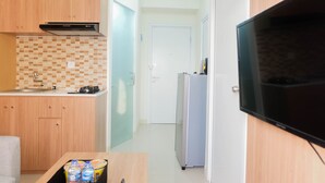Kompakti keittiö, jossa on mikroaaltouuni, liesi ja jääkaappi.