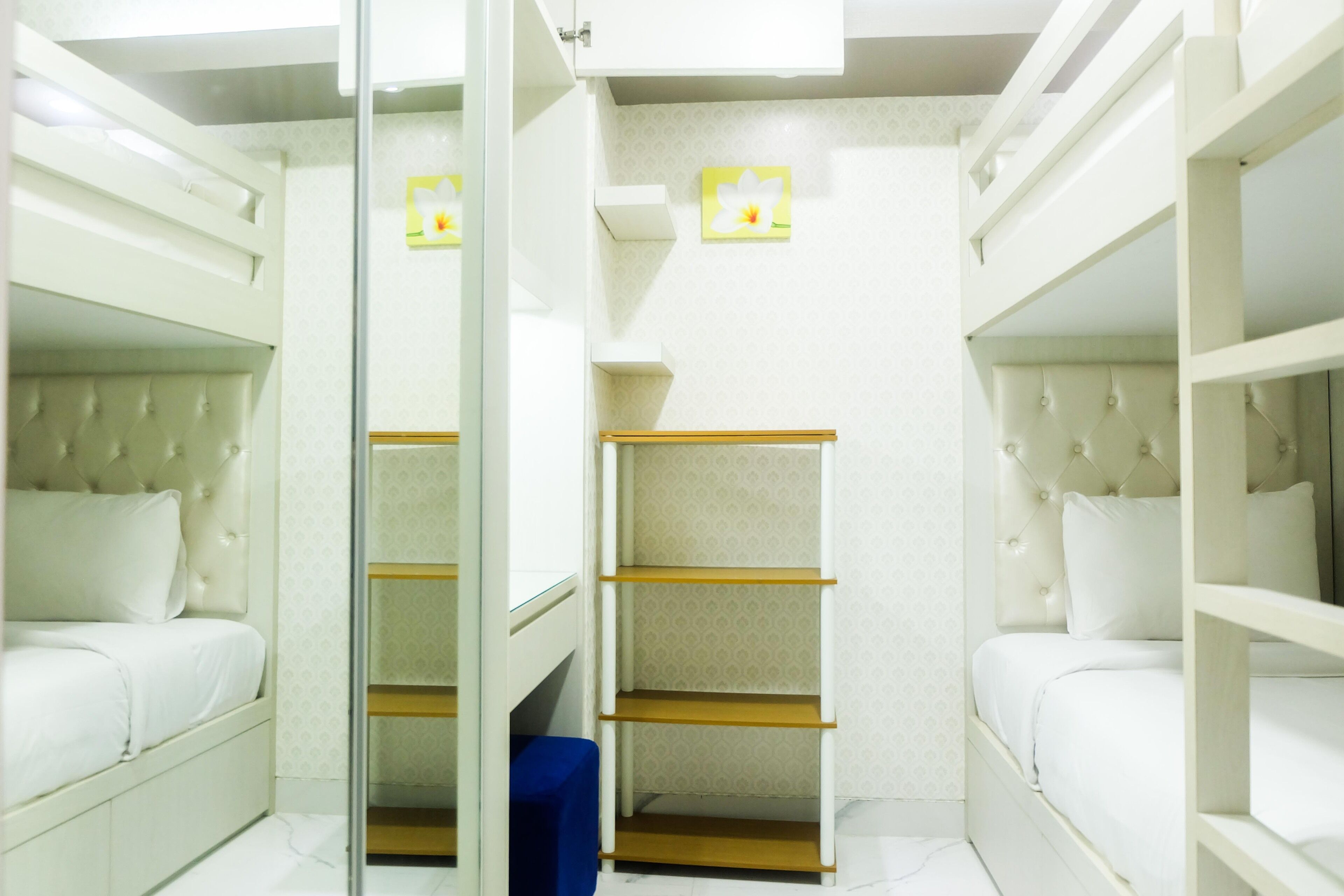 A compact room with bunk beds, a wardrobe, and a small seating area.