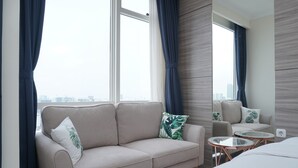 A modern hotel room with a sofa, a small round table, and a bed. - Cozy and Tranquil Studio Menteng Park Apartment (Jakarta)
