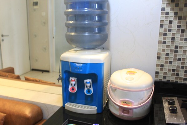 A water dispenser and a rice cooker on a counter.