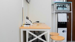 A compact kitchenette with a microwave, coffee maker, and water dispenser. - Comfy and Warm Studio Grand Kamala Lagoon Apartment (Bekasi)