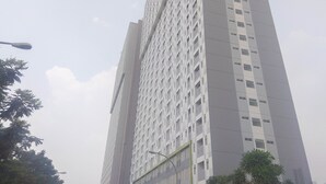 A tall, modern building with a grid-like facade and evenly spaced windows. - New Furnished Studio Apartment at Gunung Putri Square (Gunung Putri)
