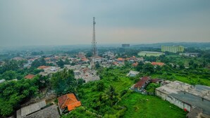 A high vantage point view of a town with a prominent communication tower, residential buildings, and greenery. - Studio Apartment Bogorienze Resort near The Jungle Water Adventure (Bogor)