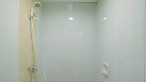 A small, enclosed shower area with a handheld showerhead and a wall-mounted faucet. - Comfortable Studio Apartment at Taman Melati near Universitas Indonesia (Depok)