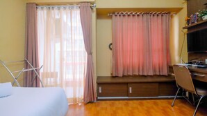 A room with a bed, a desk, and a window with curtains. - Comfortable Studio Apartment at Taman Melati near Universitas Indonesia (Depok)