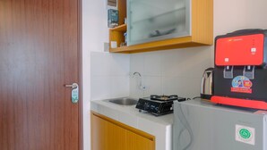 Una cocina compacta con microondas, cafetera y refrigerador.