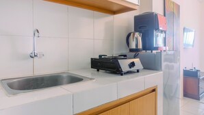 Una cocina con un lavamanos de acero inoxidable, una estufa a gas y una cafetera.