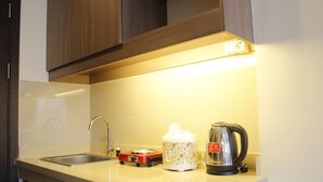 A kitchen with a sink, a kettle, a coffee maker, and a toaster. - Compact Studio Room @ Galeri Ciumbuleuit 2 Apartment (Bandung)