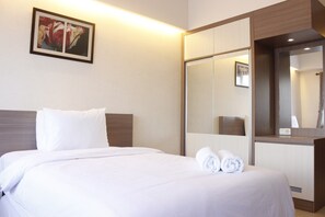 A hotel room with a bed, a large mirror, and a framed picture on the wall. - Compact Studio Room @ Galeri Ciumbuleuit 2 Apartment (Bandung)