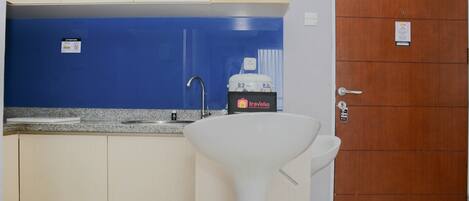 A small kitchenette with a sink, a water dispenser, and a cabinet.