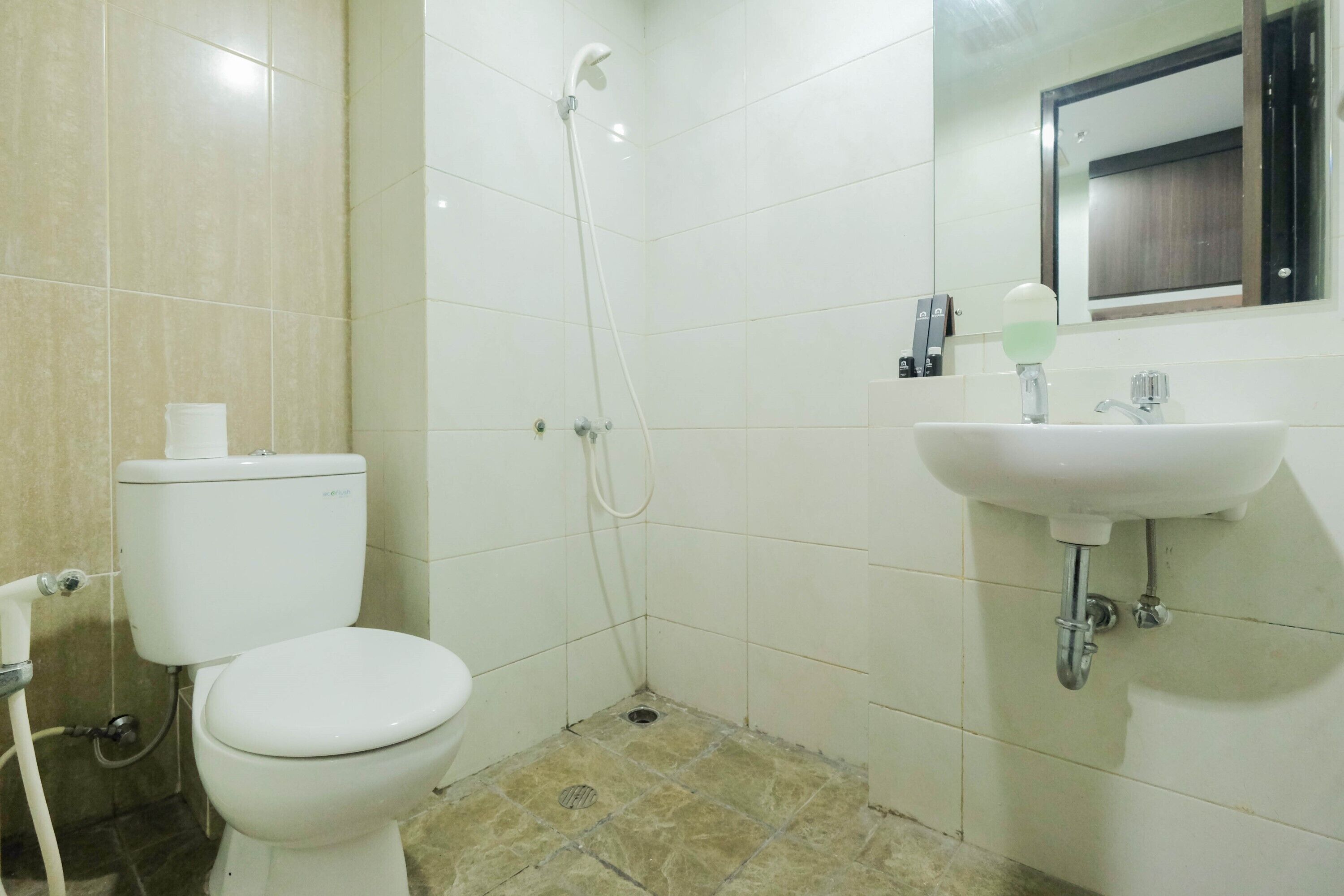 A bathroom with a toilet, a shower, and a sink.