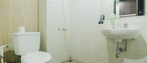 A bathroom with a toilet, a shower, and a sink.